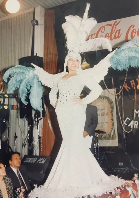 Una joven con un traje de carnaval blanco de plumas.