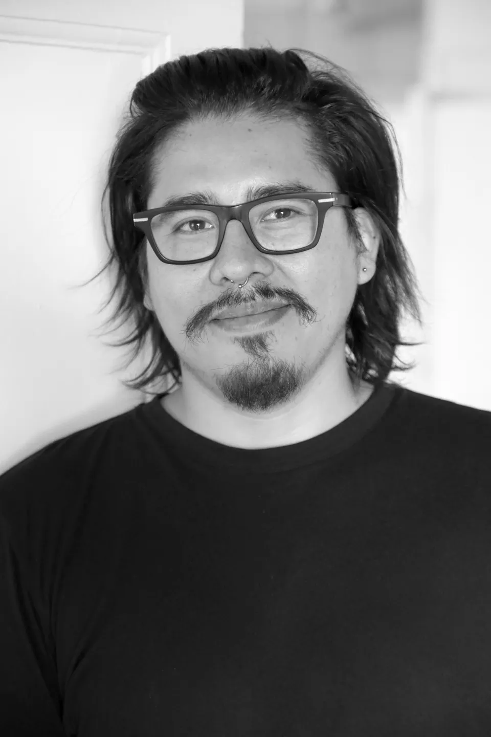 Un hombre con lentes, en blanco y negro.