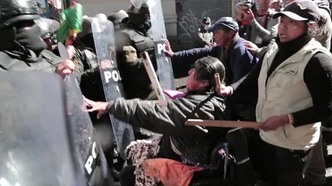 Fotograma de The Fight: policías antimotines con escudos empujan contra los manifestantes.