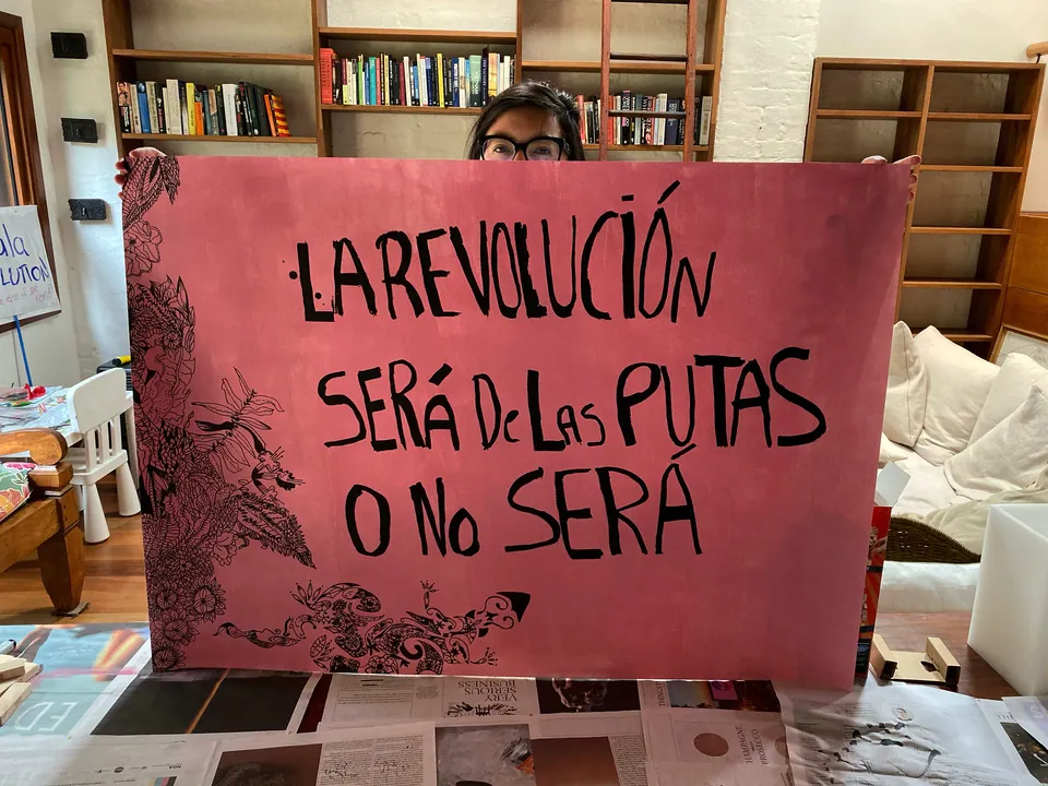 Una mujer sostiene un cartel: la revolución será de las putas o no será.