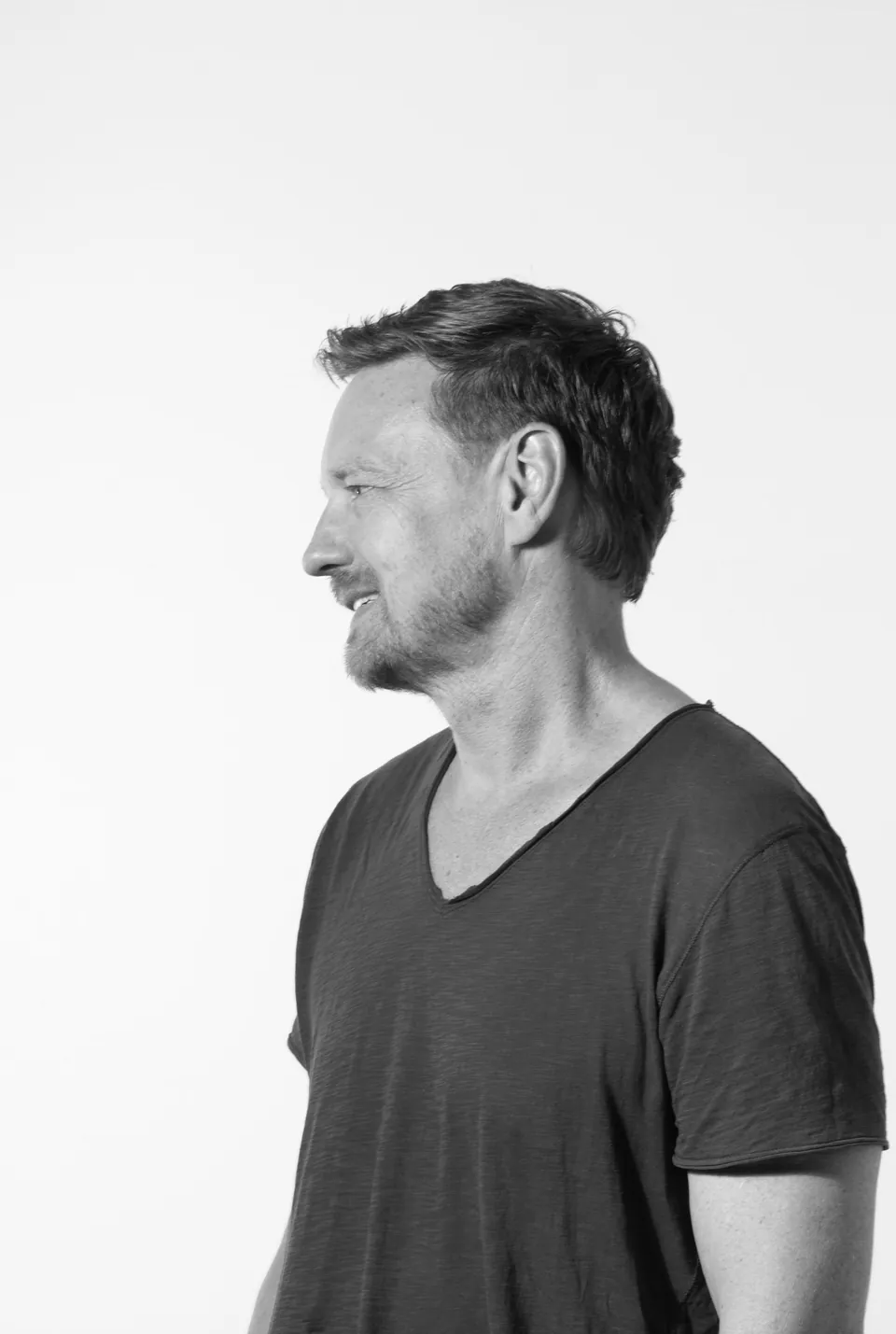 Un hombre de polera, de perfil, en blanco y negro.