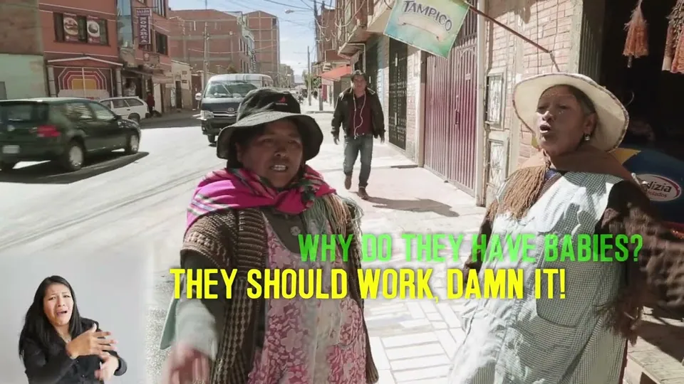 Fotograma de La Lucha: dos mujeres con sombrero hablan en una calle.